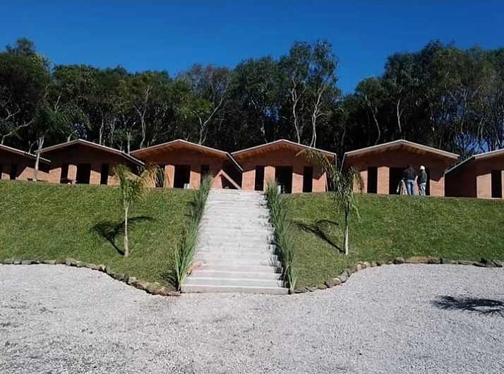 Conjunto de chalés de tijolo à vista com escadaria e gramado
