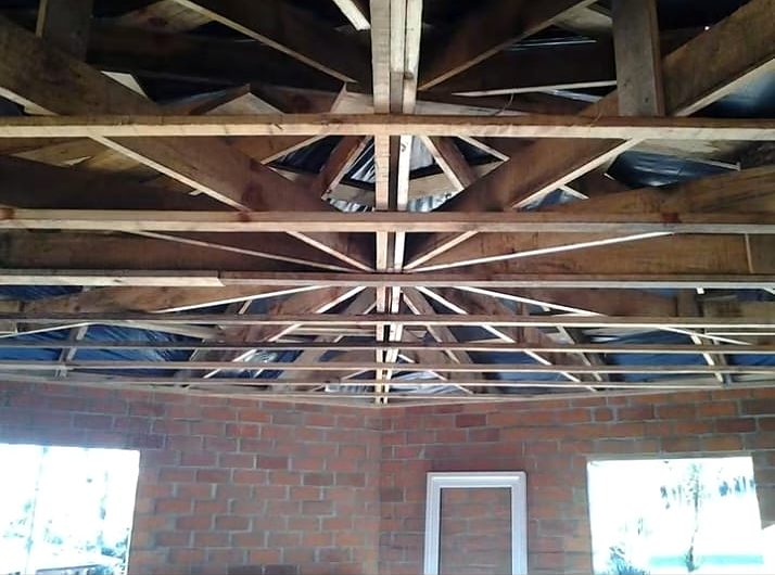 Estrutura de madeira do telhado sobre paredes de tijolo